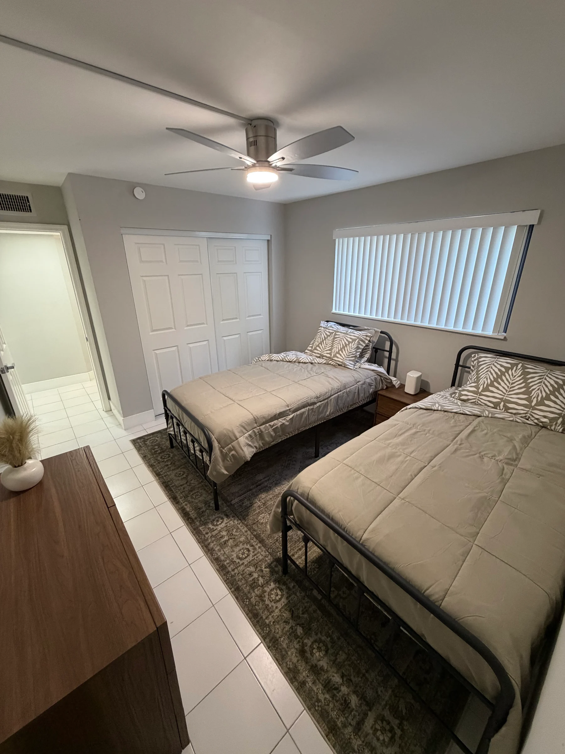 Two furnished beds with fresh linens in a semi-private bedroom.