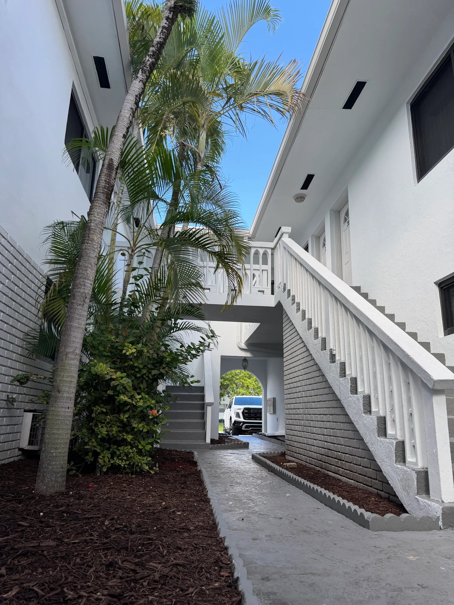 Palm trees and white architecture in the residence courtyard.